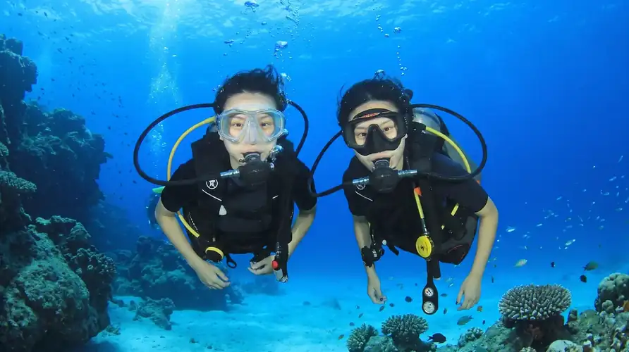 An expert dive buddy assisting local scuba divers with Pavalintang Resort in the Celebes Sea